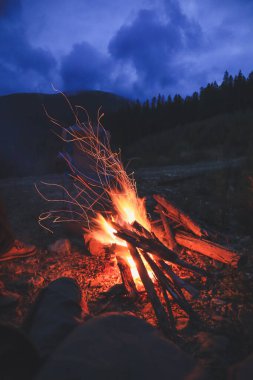 Turistler dağlara bakan ateşin tadını çıkarıyorlar. Sonbaharda sıcak bir atmosfer. Ukrayna Karpat Dağları