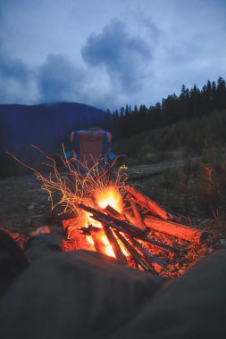 Turistler dağlara bakan ateşin tadını çıkarıyorlar. Sonbaharda sıcak bir atmosfer. Ukrayna Karpat Dağları