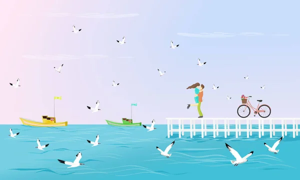 Çiftler denize uzanan beyaz bir köprüde sarıldılar. Arka plan olarak martılar ve Balıkçı teknesi yanında bir bisiklet var