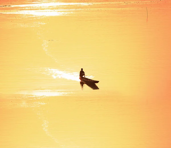 Silhueta de pescadores Pegue um pequeno barco de pesca para o rio a — Fotografia de Stock