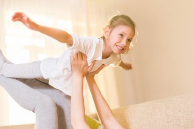 Annem ve onun sevimli kız çocuk, gülümseyerek ve sarılma oynuyorlar. Mutlu anneler günü. Aile tatili ve beraberlik