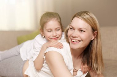 Annem ve onun sevimli kız çocuk, gülümseyerek ve sarılma oynuyorlar. Mutlu anneler günü. Aile tatili ve beraberlik