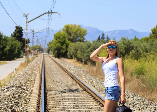 Atraktivní mladá žena dlouhé hnědé vlasy, chůze v blízkosti železnice — Stock fotografie