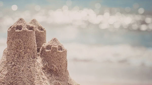 Na pláži stojí hrad z písku. Koncept cestovních dovolených — Stock fotografie