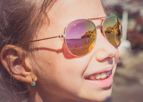 Krásná mladá dívka v sluneční brýle s beach reflexe. — Stock fotografie