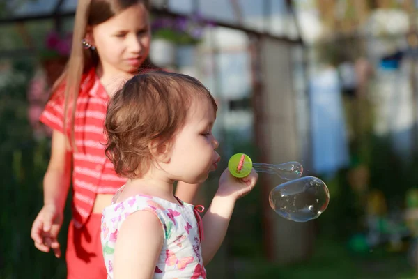 Linda niña está soplando una burbuja de jabón — Foto de Stock