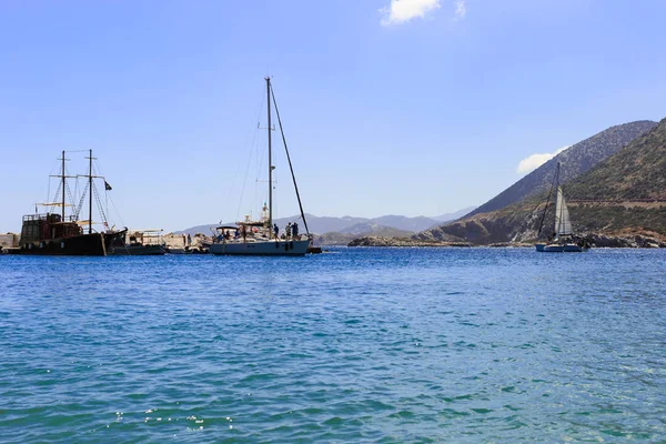 Witte zeilboot in de open zee. Zeiljacht in de open zee met de bergen op de achtergrond. — Stockfoto