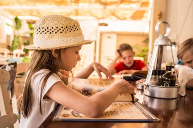 Cafe menü ile mutlu genç kız. Güzel tatil kız restoranda akşam yemeği.