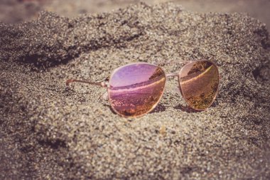 Deniz yansıması ile plajda güneş gözlüğü.