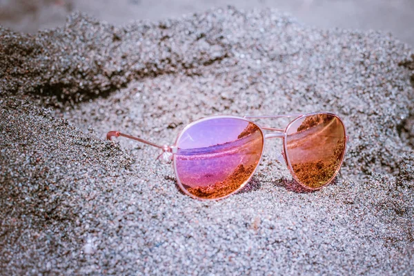 Occhiali da sole in spiaggia con riflesso del mare . — Foto Stock