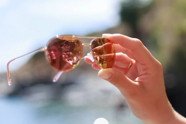 Napszemüveg, női kéz a strandon magát elmélkedés. — Stock Fotó