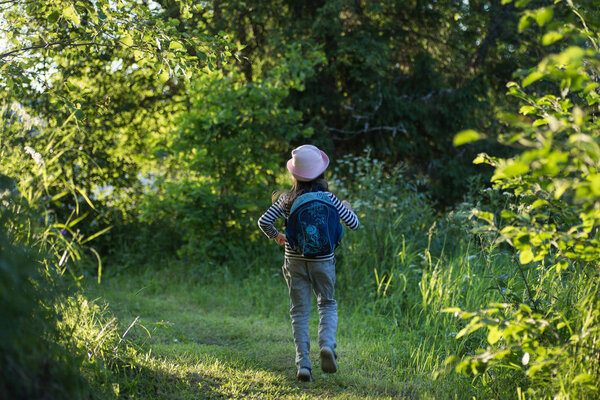 Traveler girl with backpack walking on path in the tropical forest