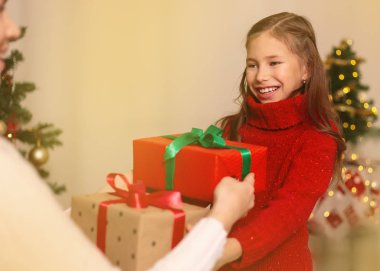 Neşeli anne ve sevimli kızı hediye alışverişi. Mutlu Noeller ve mutlu tatiller.