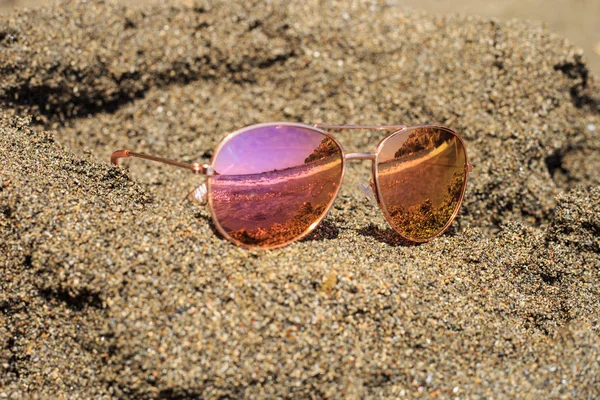 Okulary przeciwsłoneczne na plaży z widokiem na odbicia. — Zdjęcie stockowe