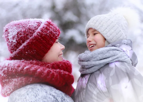 Ευτυχισμένη οικογένεια μητέρα και παιδί κόρη διασκεδάζουν, παίζοντας το χειμώνα με τα πόδια σε εξωτερικούς χώρους — Φωτογραφία Αρχείου
