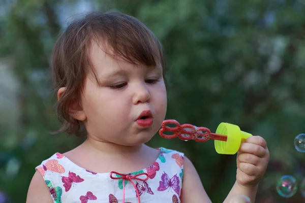 Linda niña está soplando una burbuja de jabón — Foto de Stock