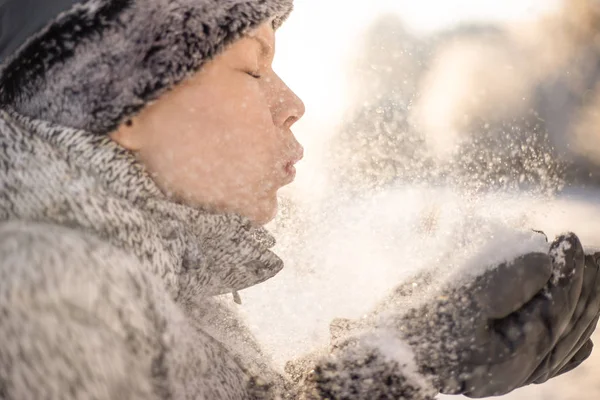 Μια ομορφιά κορίτσι φυσάει στο χιόνι για το φόντο του χειμώνα — Φωτογραφία Αρχείου