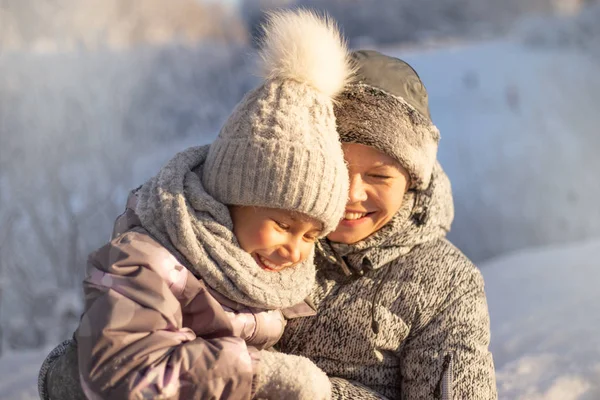 Mère et enfant fille avoir du plaisir, jouer et rire sur l'hiver neigeux . Photos De Stock Libres De Droits