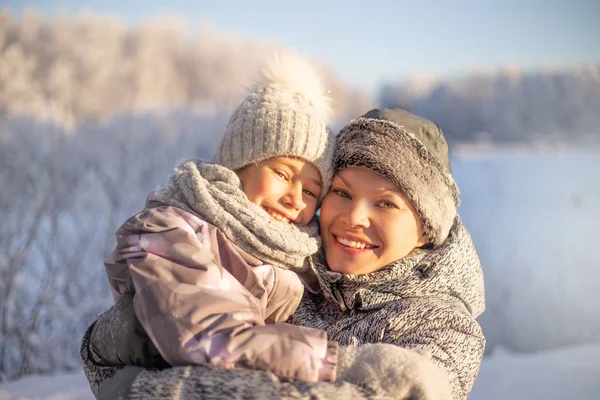 Mère et enfant fille avoir du plaisir, jouer et rire sur l'hiver neigeux . Image En Vente