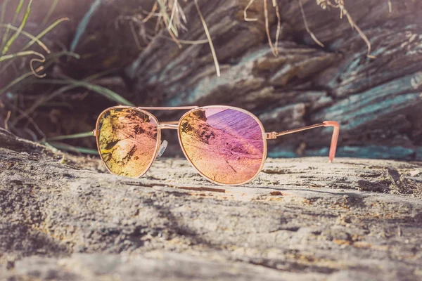 Occhiali da sole in spiaggia con riflesso del mare . — Foto Stock