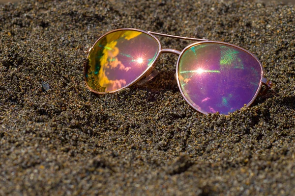 Sonnenbrille am Strand mit Himmel und Sonnenreflexion. — Stockfoto