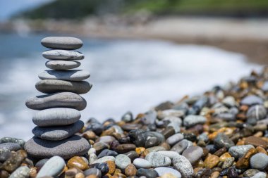 Deniz kenarında bir yığın zen taşı. Ahenk, denge