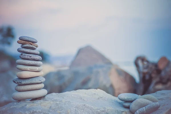 Steinpyramide auf Sand symbolisiert Zen, Harmonie, Gleichgewicht. Ozean bei Sonnenuntergang im Hintergrund — Stockfoto