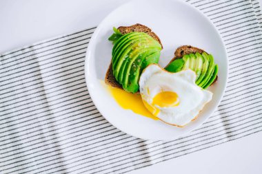 Sağlıklı avokado kızarmış ekmek ve yumurta beyaz arka plan üzerinde. Üstten görünüm. 