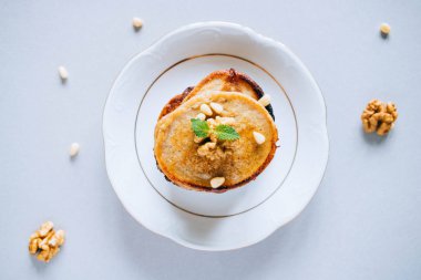 Cevizli muzlu krep ve sedir fıstığı, bal ve nane, beyaz arka planda bal sosu, üst manzara. Sabah kahvaltısı