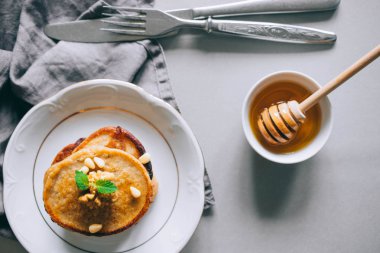 Cevizli muzlu krep ve sedir fıstığı, bal ve nane, beyaz arka planda bal sosu, üst manzara. Sabah kahvaltısı