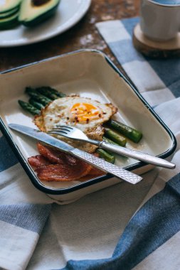 Kahvaltı kahve, avokado, kuşkonmaz, yumurta ve domuz pastırması ile yat, yukarıda paslı bir arka plan üzerinde görüntüleme