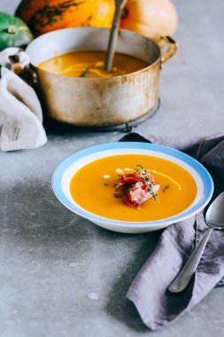 Gri arka plan üzerine balkabağı çorbası tabak