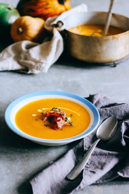 Gri arka plan üzerine balkabağı çorbası tabak