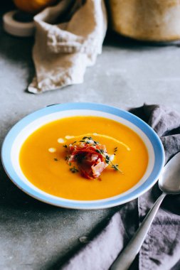 Gri arka plan üzerine balkabağı çorbası tabak