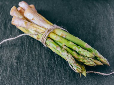 Taze yeşil kuşkonmaz ile siyah arduvaz ipe bağlı