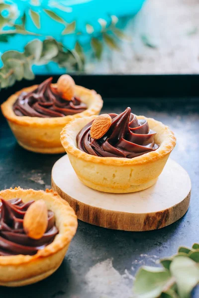 Kırmızı tartlets kısa pasta çikolata ganache ve badem metal bir tepsi ile yapılmış
