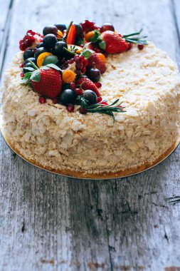 Çilek, üzüm, yaban mersini ve physalis ahşap zemin ile dekore kek Napoleon