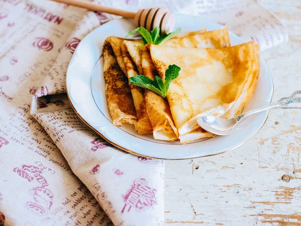 Crepes Frittelle Sottili Con Miele Menta Piatto Bianco Sfondo Legno — Foto Stock