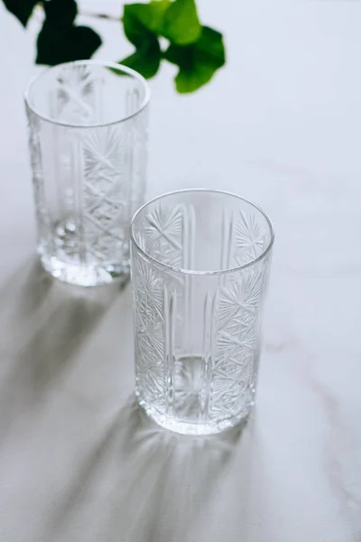 Zwei Leere Gläser Auf Marmorgrund Mit Einem Zweig Efeu — Stockfoto