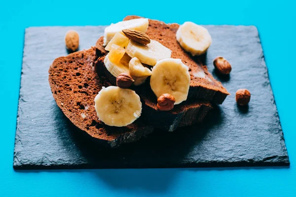 Шоколадный Банановый Хлеб Черной Доске Бананами Орехами Завтрак Синем Фоне — стоковое фото