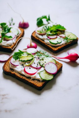 Turp, salatalık ve karanlık ekmek ışık mermer zemin siyah susam tost