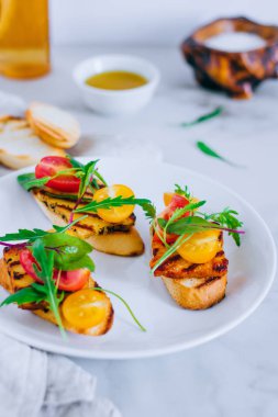 Bruschetta ızgara haloumi peynir, pazı ve roka ile kiraz domates salatası ile