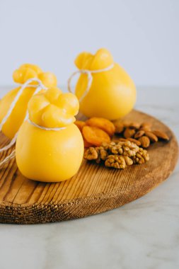 Scamorza peynir ile ceviz, badem ve yer üstünde a ahşap tahta, mermer arka plan, kopyalama.