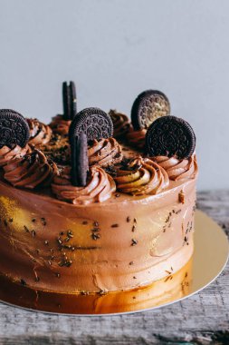 Surgut, Rusya - Nisan 2016: Altın pullu bukleler ve bisküvi Oreo ahşap arka plan üzerinde süslenmiş ile çikolatalı kek