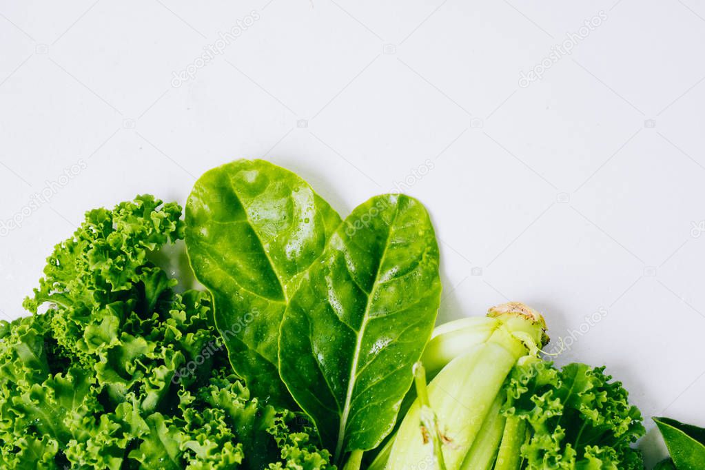 Frame of fresh green vegetables with a drop of water on a marble background, copy space, flay lay, top view