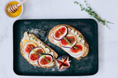 Bruschetta incir ve keçi peyniri siyah metal tepsisindeki yatıyordu, en iyi görünüm düz