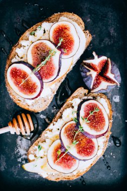 Bruschetta incir ve keçi peyniri siyah metal tepsisindeki yatıyordu, en iyi görünüm düz