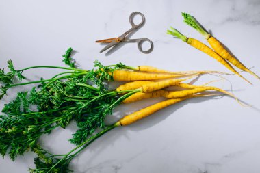Taze sarı havuç ile bir üstleri düz yatıyordu, en iyi görünüm, mermer bir arka plan yıkanmış.