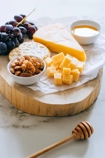 Cheddar Käse Trauben Nüsse Honig Und Cracker Holzplatte Auf Marmor — Stockfoto