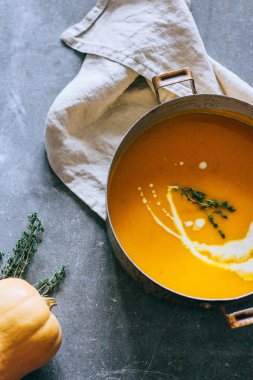 Güveç krem ve kekik gri bir arka planda üstten görünüm ile kabak çorbası